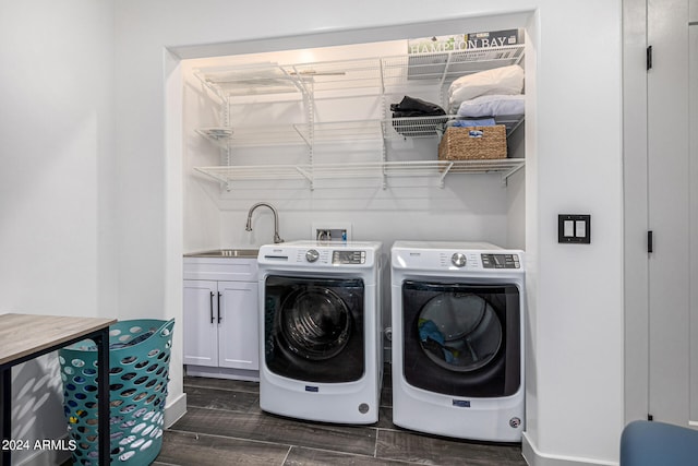 clothes washing area featuring washer and dryer, sink, dark wood-type flooring, and cabinets