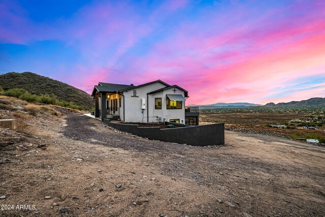 property exterior at dusk with a mountain view