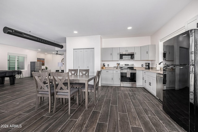 kitchen with appliances with stainless steel finishes, pool table, dark wood-type flooring, and ceiling fan