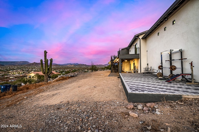 yard at dusk featuring a balcony and a mountain view