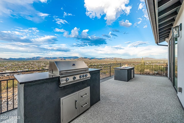 view of patio / terrace featuring grilling area, a mountain view, and exterior kitchen