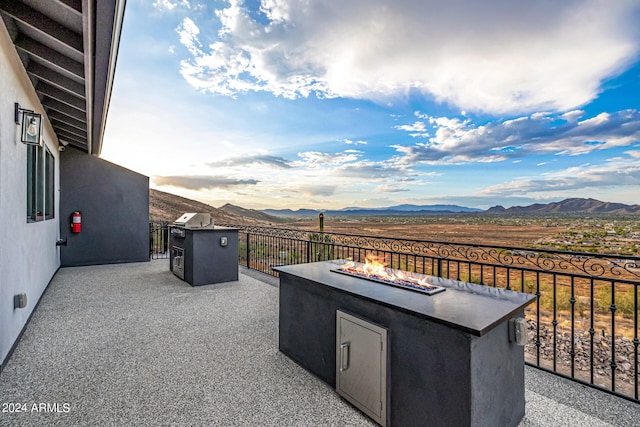 view of patio / terrace with a mountain view and an outdoor fire pit