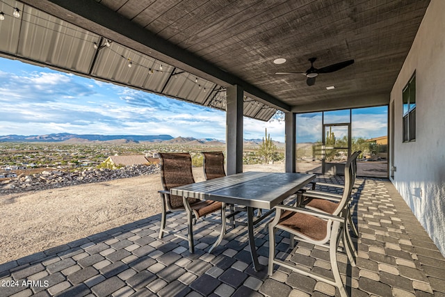 view of patio featuring ceiling fan and a mountain view