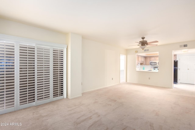 unfurnished living room with ceiling fan and light colored carpet