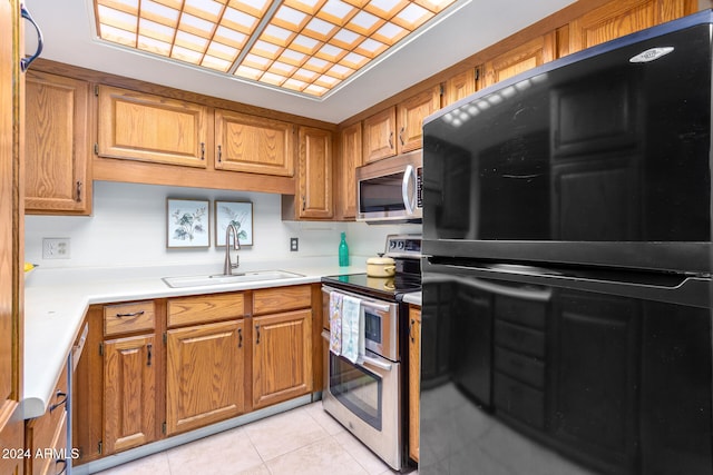 kitchen featuring sink, light tile patterned flooring, and stainless steel appliances