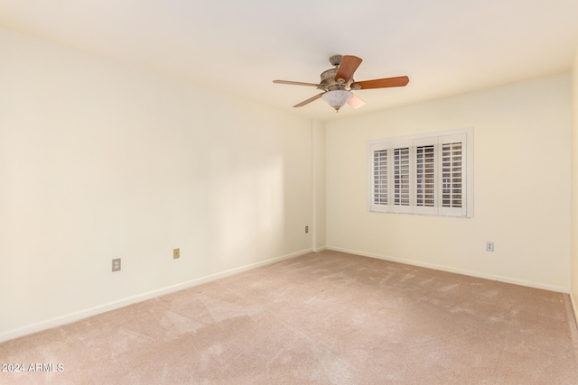 carpeted spare room with ceiling fan