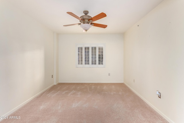 carpeted spare room featuring ceiling fan