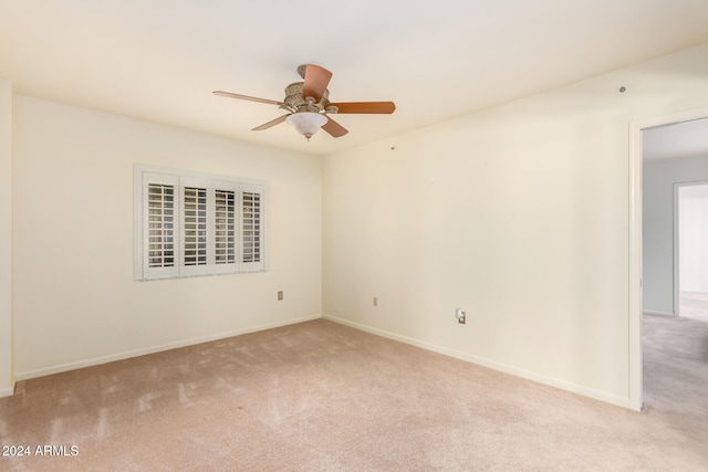 carpeted spare room featuring ceiling fan