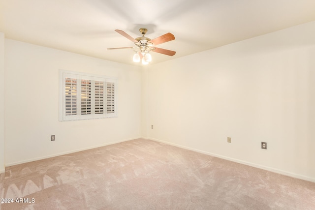 carpeted spare room featuring ceiling fan