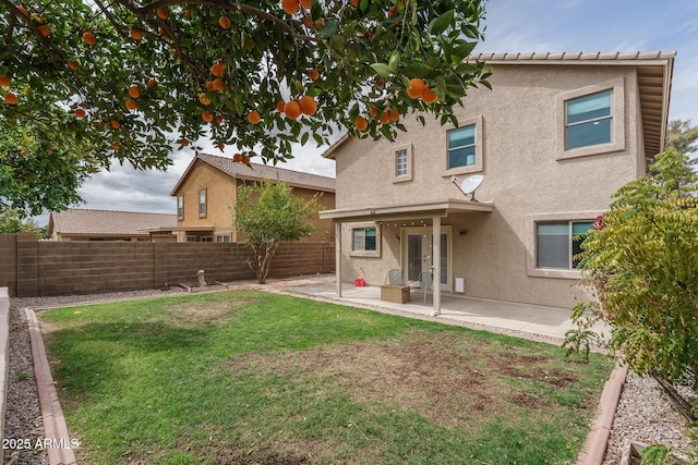 back of property with a patio, a fenced backyard, a lawn, and stucco siding