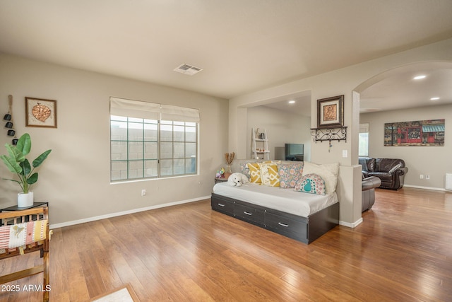 bedroom featuring wood finished floors, visible vents, baseboards, recessed lighting, and arched walkways