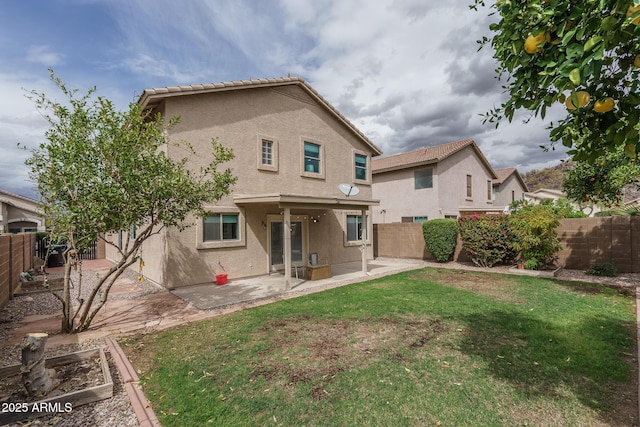 rear view of house featuring a yard, a patio area, a fenced backyard, and stucco siding