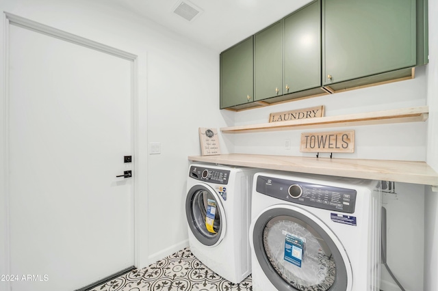 clothes washing area featuring cabinets and washing machine and dryer