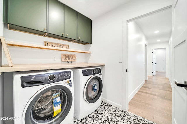 washroom featuring independent washer and dryer, cabinets, and light hardwood / wood-style floors