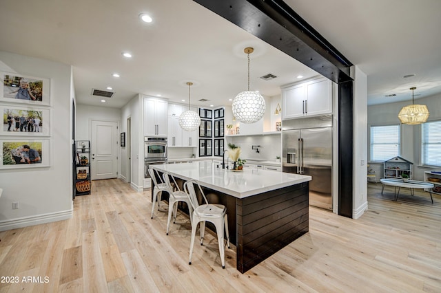 22406 S 173rd Way, Gilbert, AZ 85298 - kitchen featuring stainless steel appliances, a chandelier, white cabinets, light wood-style flooring, and recessed lighting