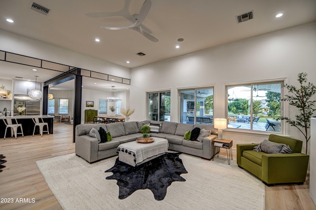 22406 S 173rd Way, Gilbert, AZ 85298 - living room featuring ceiling fan, light wood-style flooring, recessed lighting, a high ceiling, and a chandelier
