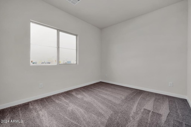 carpeted spare room featuring visible vents and baseboards