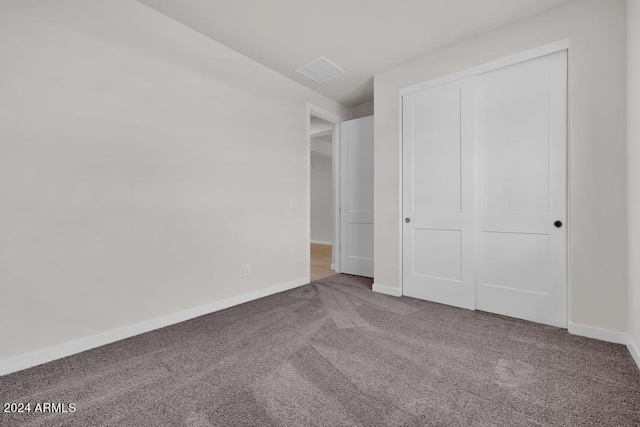 unfurnished bedroom featuring carpet, a closet, and baseboards