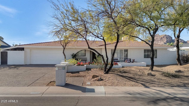 ranch-style house featuring an attached garage, driveway, and brick siding