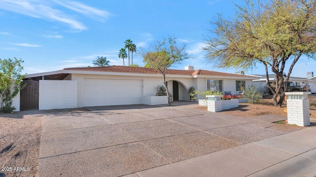 ranch-style home with concrete driveway, brick siding, and an attached garage