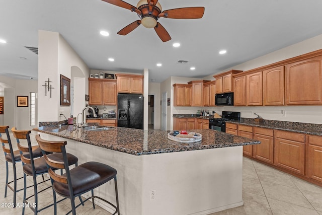 3018 E Vernon St, Gilbert, AZ 85298 - kitchen with black appliances, a ceiling fan, dark stone counters, a breakfast bar, and recessed lighting