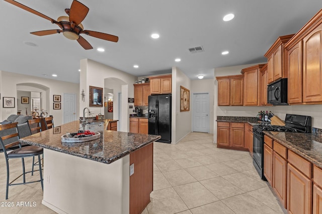 3018 E Vernon St, Gilbert, AZ 85298 - kitchen featuring black appliances, arched walkways, a ceiling fan, a breakfast bar area, and dark stone countertops
