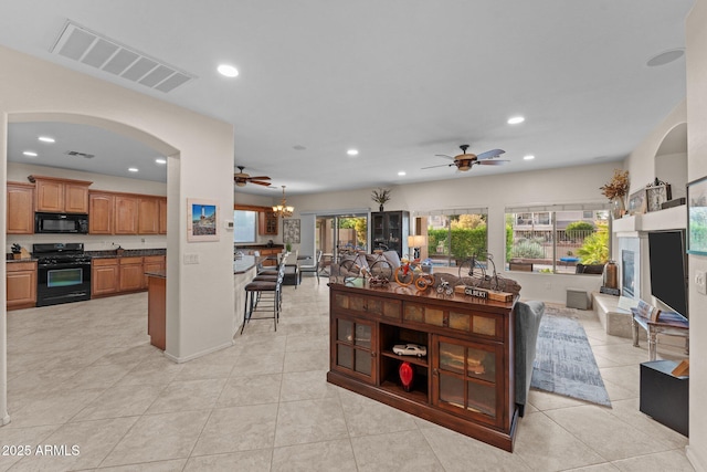 3018 E Vernon St, Gilbert, AZ 85298 - living area featuring a ceiling fan, recessed lighting, a fireplace with raised hearth, light tile patterned floors, and arched walkways