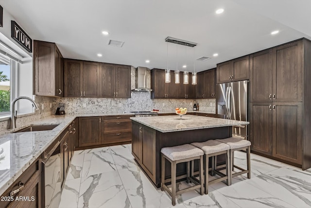 5101 E Paradise Dr, Scottsdale, AZ 85254 - kitchen featuring wall chimney range hood, stainless steel fridge with ice dispenser, dishwasher, light marble finish flooring, and recessed lighting