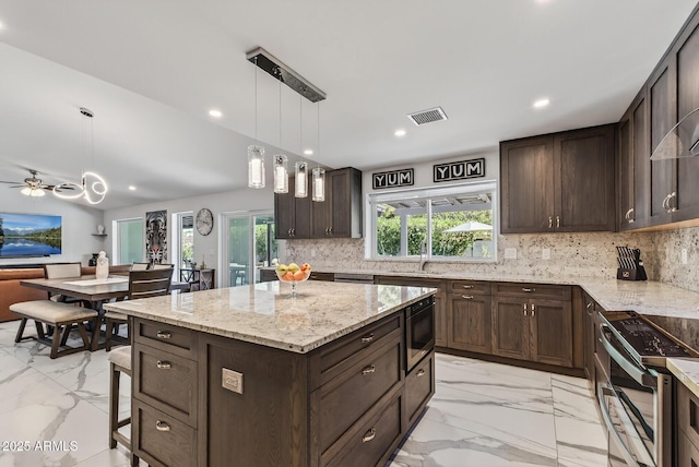 5101 E Paradise Dr, Scottsdale, AZ 85254 - kitchen featuring appliances with stainless steel finishes, light marble finish floors, dark brown cabinets, light stone counters, and recessed lighting