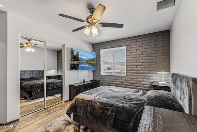 5101 E Paradise Dr, Scottsdale, AZ 85254 - bedroom with wood finished floors, a closet, a ceiling fan, and brick wall