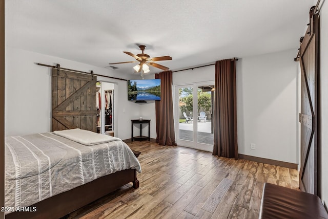 5101 E Paradise Dr, Scottsdale, AZ 85254 - bedroom featuring a barn door, access to outside, wood finished floors, and a spacious closet