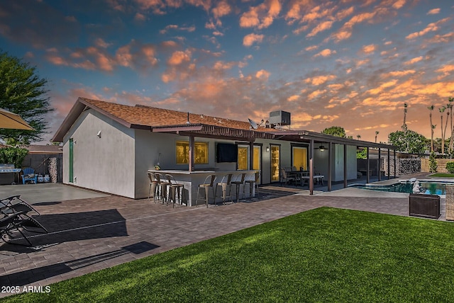 5101 E Paradise Dr, Scottsdale, AZ 85254 - back of property at dusk with a yard, stucco siding, and a patio