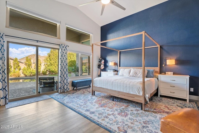 bedroom with access to exterior, light hardwood / wood-style floors, vaulted ceiling, and ceiling fan