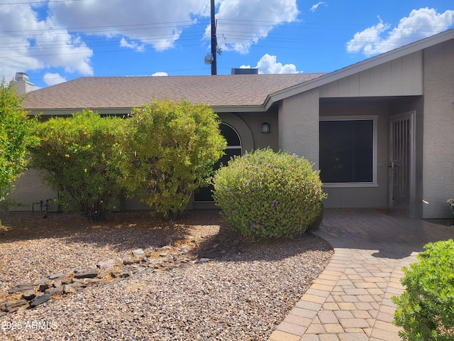 view of property exterior featuring roof with shingles and stucco siding