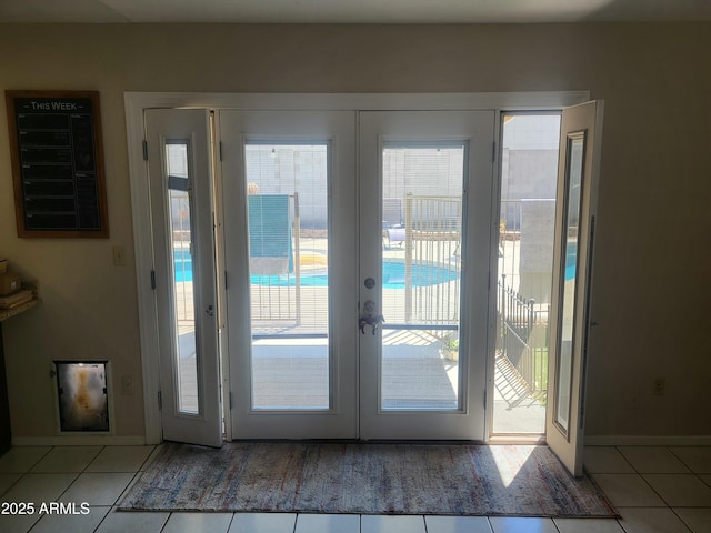 entryway with tile patterned floors, baseboards, and french doors