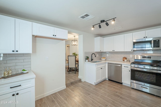 kitchen with decorative backsplash, sink, white cabinets, and appliances with stainless steel finishes