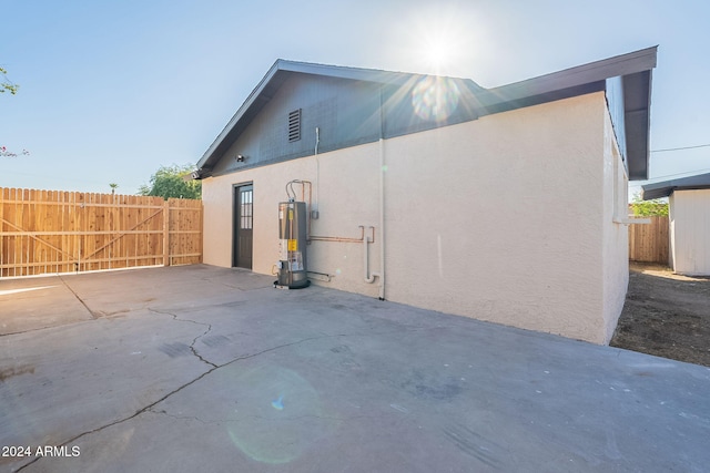 view of property exterior featuring gas water heater and a patio area