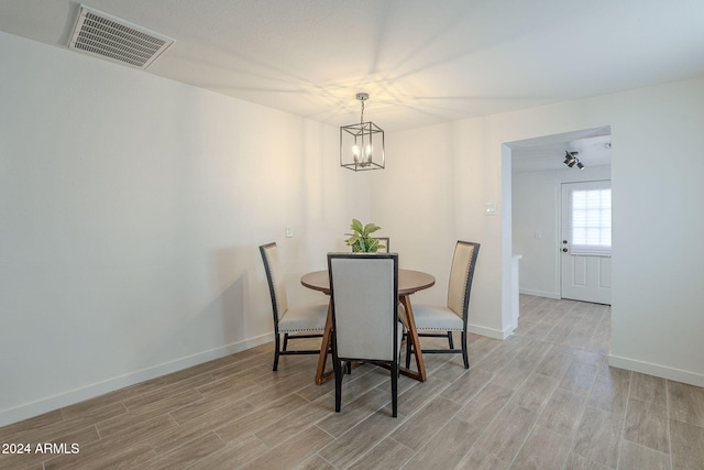 dining space with a chandelier and light hardwood / wood-style flooring