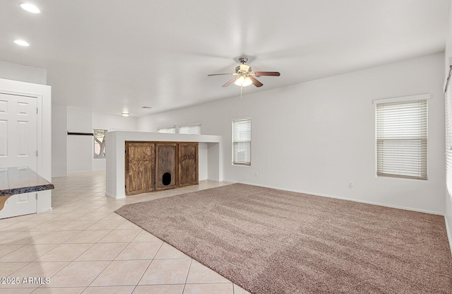 unfurnished living room featuring ceiling fan and light tile patterned floors