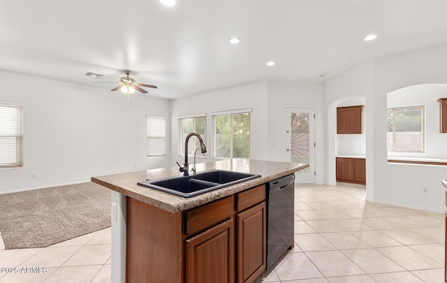 kitchen featuring dishwasher, sink, ceiling fan, light tile patterned floors, and an island with sink