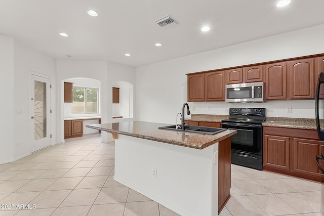 kitchen with a kitchen island with sink, sink, light tile patterned floors, black / electric stove, and stone countertops