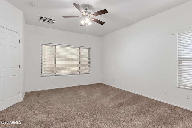 carpeted spare room featuring ceiling fan and a healthy amount of sunlight