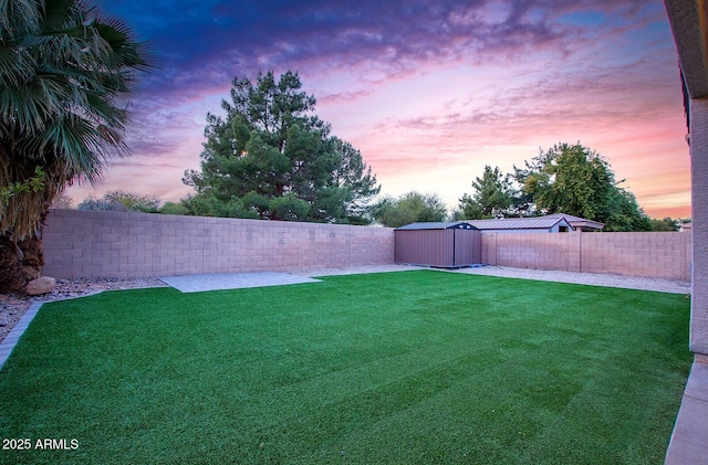 yard at dusk featuring a shed