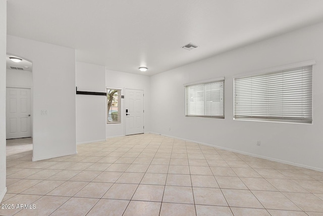 unfurnished room with plenty of natural light and light tile patterned floors