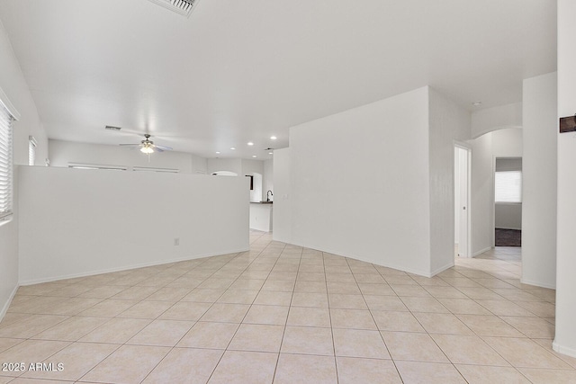 unfurnished room featuring light tile patterned floors, a wealth of natural light, and ceiling fan