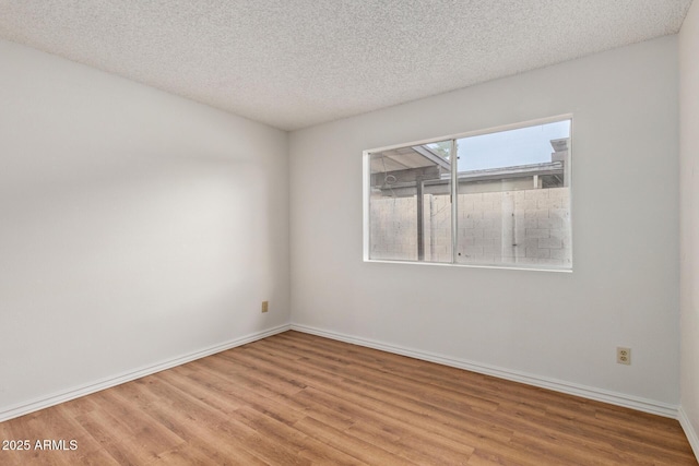 unfurnished room with light hardwood / wood-style floors and a textured ceiling