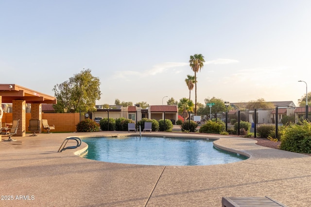 pool at dusk featuring a patio