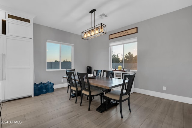 dining area with a wealth of natural light, visible vents, and light wood-style flooring