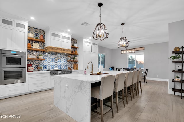 kitchen with visible vents, white cabinets, appliances with stainless steel finishes, open shelves, and glass insert cabinets