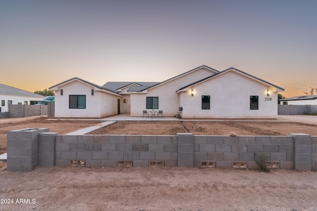 view of front facade with fence private yard, a patio area, and stucco siding